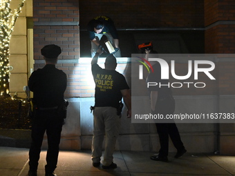 New York City Police Department crime scene investigators swab for evidence outside the One Carnegie Hill luxury rental apartment complex lo...