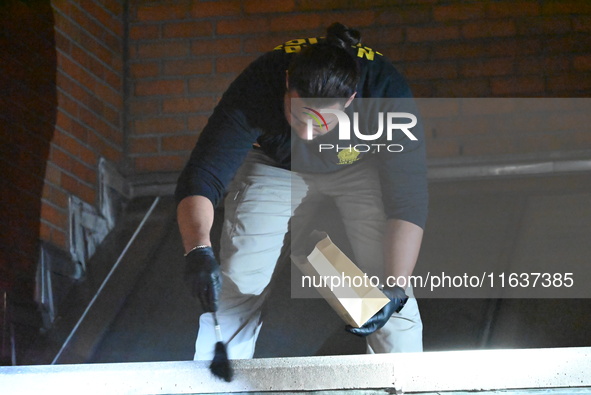 New York City Police Department crime scene investigators swab for evidence outside the One Carnegie Hill luxury rental apartment complex lo...