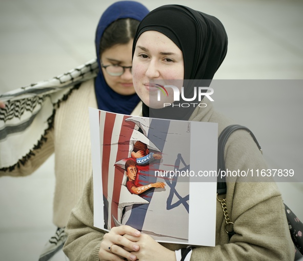 A woman folds a placard with Israeli and American flags on it during in a rally in support of Palestine at the Royal Castle Square in Warsaw...