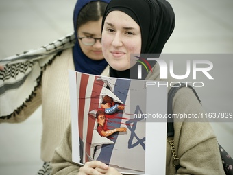 A woman folds a placard with Israeli and American flags on it during in a rally in support of Palestine at the Royal Castle Square in Warsaw...