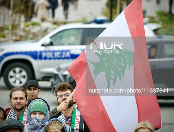 A man holds a Lebanese flag a rally in support of Palestine at the Royal Castle Square in Warsaw, Poland on 05 October, 2024.  