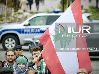 A man holds a Lebanese flag a rally in support of Palestine at the Royal Castle Square in Warsaw, Poland on 05 October, 2024.  (