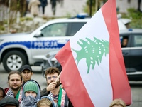 A man holds a Lebanese flag a rally in support of Palestine at the Royal Castle Square in Warsaw, Poland on 05 October, 2024.  (