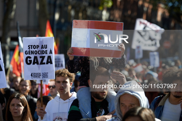 A girl holds a Lebanese flag while on the shoulders of her father. Hundreds of people demonstrate in Toulouse, France, on October 5, 2024, i...