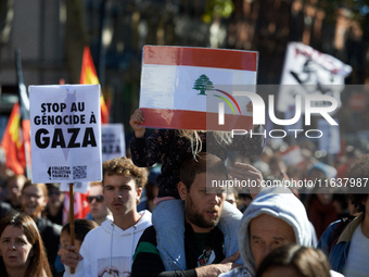 A girl holds a Lebanese flag while on the shoulders of her father. Hundreds of people demonstrate in Toulouse, France, on October 5, 2024, i...