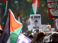 A woman holds a placard reading 'Lebanon bleeds but resists'. Hundreds of people demonstrate in Toulouse, France, on October 5, 2024, in sup...