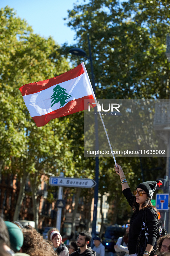 A woman waves the Lebanese flag during the protest. Hundreds of people demonstrate in Toulouse, France, on October 5, 2024, in support of Ga...