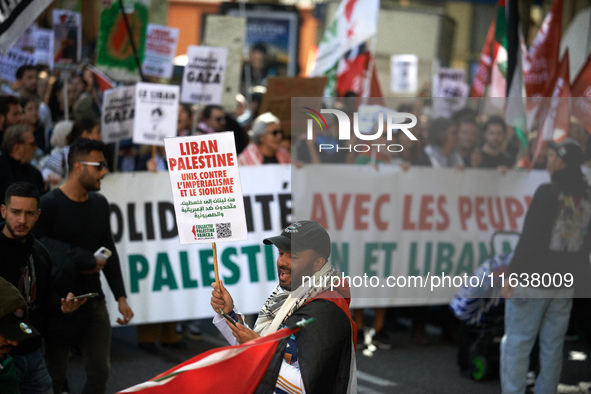 A protester holds a placard reading 'Lebanon, Palestine, united against imperialism and Zionism'. Hundreds of people demonstrate in Toulouse...