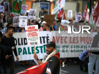 A protester holds a placard reading 'Lebanon, Palestine, united against imperialism and Zionism'. Hundreds of people demonstrate in Toulouse...