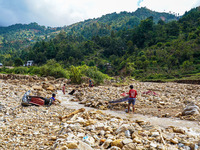 Children search for their belongings in damaged houses due to Nakhu River flooding in the Bhardev region of southern Lalitpur, Nepal, on Oct...