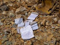 Scattered book papers lie in front of damaged homes in the Bhardev region of southern Lalitpur, Nepal, on October 5, 2024. (