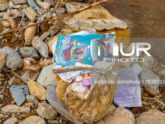 Scattered book papers lie in front of damaged homes in the Bhardev region of southern Lalitpur, Nepal, on October 5, 2024. (