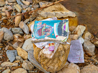 Scattered book papers lie in front of damaged homes in the Bhardev region of southern Lalitpur, Nepal, on October 5, 2024. (