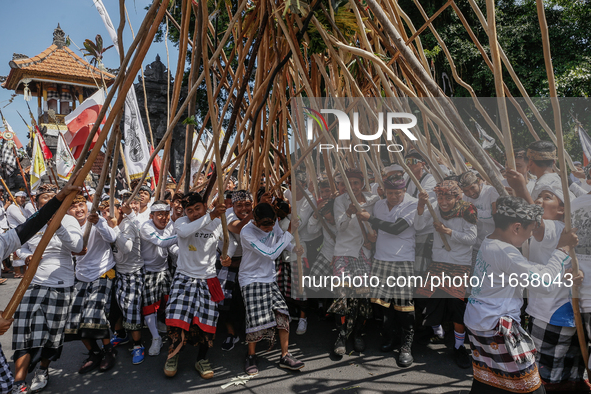 Balinese men make pyramid-like structures using long wooden sticks during the Mekotek ritual in Munggu Village, Bali, Indonesia, on October...