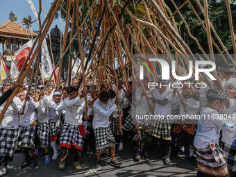 Balinese men make pyramid-like structures using long wooden sticks during the Mekotek ritual in Munggu Village, Bali, Indonesia, on October...