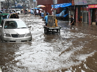 Vehicles and rickshaws drive with passengers through the waterlogged streets of Dhaka, Bangladesh, on October 5, 2024, after heavy rainfalls...