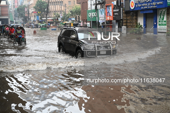 Vehicles and rickshaws drive with passengers through the waterlogged streets of Dhaka, Bangladesh, on October 5, 2024, after heavy rainfalls...