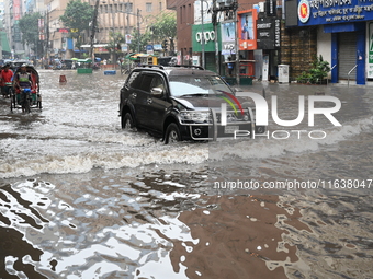 Vehicles and rickshaws drive with passengers through the waterlogged streets of Dhaka, Bangladesh, on October 5, 2024, after heavy rainfalls...