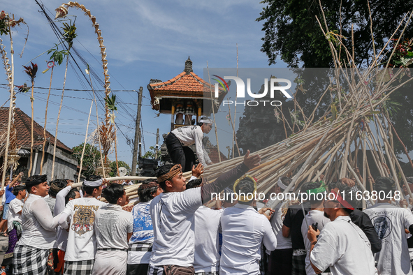 A Balinese man climbs pyramid-like structures using long wooden sticks during the Mekotek ritual in Munggu Village, Bali, Indonesia, on Octo...