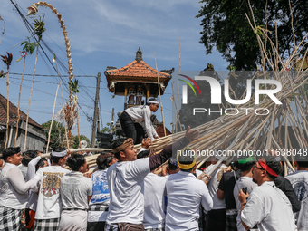 A Balinese man climbs pyramid-like structures using long wooden sticks during the Mekotek ritual in Munggu Village, Bali, Indonesia, on Octo...