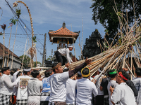 A Balinese man climbs pyramid-like structures using long wooden sticks during the Mekotek ritual in Munggu Village, Bali, Indonesia, on Octo...