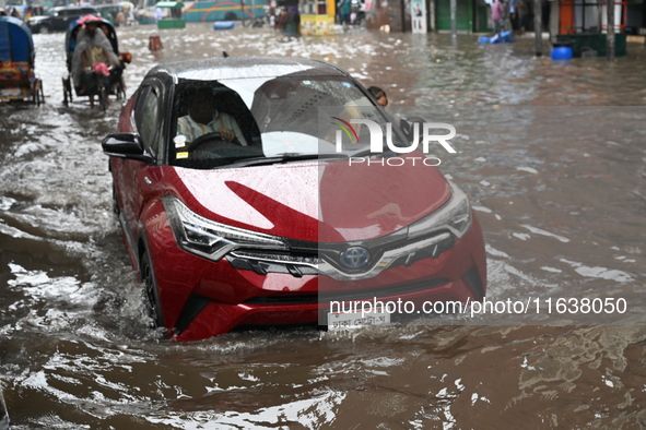 Vehicles and rickshaws drive with passengers through the waterlogged streets of Dhaka, Bangladesh, on October 5, 2024, after heavy rainfalls...