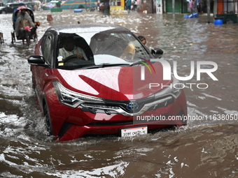 Vehicles and rickshaws drive with passengers through the waterlogged streets of Dhaka, Bangladesh, on October 5, 2024, after heavy rainfalls...