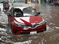 Vehicles and rickshaws drive with passengers through the waterlogged streets of Dhaka, Bangladesh, on October 5, 2024, after heavy rainfalls...