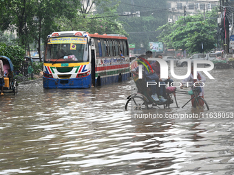 Vehicles and rickshaws drive with passengers through the waterlogged streets of Dhaka, Bangladesh, on October 5, 2024, after heavy rainfalls...