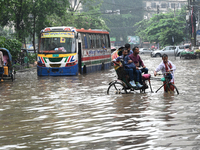 Vehicles and rickshaws drive with passengers through the waterlogged streets of Dhaka, Bangladesh, on October 5, 2024, after heavy rainfalls...