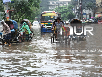 Vehicles and rickshaws drive with passengers through the waterlogged streets of Dhaka, Bangladesh, on October 5, 2024, after heavy rainfalls...