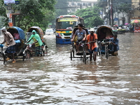 Vehicles and rickshaws drive with passengers through the waterlogged streets of Dhaka, Bangladesh, on October 5, 2024, after heavy rainfalls...