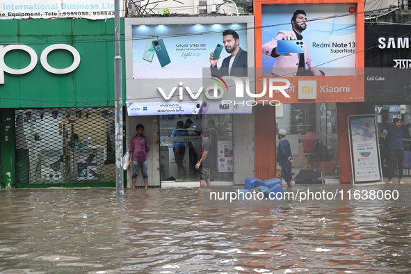 Vehicles and rickshaws drive with passengers through the waterlogged streets of Dhaka, Bangladesh, on October 5, 2024, after heavy rainfalls...