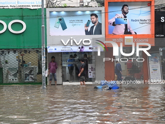 Vehicles and rickshaws drive with passengers through the waterlogged streets of Dhaka, Bangladesh, on October 5, 2024, after heavy rainfalls...