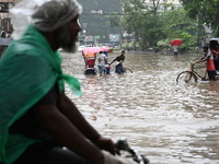 Vehicles and rickshaws drive with passengers through the waterlogged streets of Dhaka, Bangladesh, on October 5, 2024, after heavy rainfalls...