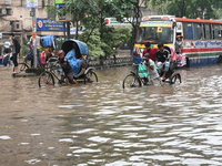 Vehicles and rickshaws drive with passengers through the waterlogged streets of Dhaka, Bangladesh, on October 5, 2024, after heavy rainfalls...