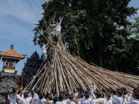 A Balinese man climbs pyramid-like structures using long wooden sticks during the Mekotek ritual in Munggu Village, Bali, Indonesia, on Octo...