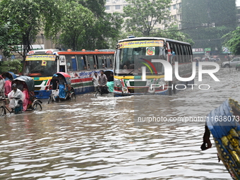 Vehicles and rickshaws drive with passengers through the waterlogged streets of Dhaka, Bangladesh, on October 5, 2024, after heavy rainfalls...