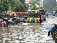 Vehicles and rickshaws drive with passengers through the waterlogged streets of Dhaka, Bangladesh, on October 5, 2024, after heavy rainfalls...