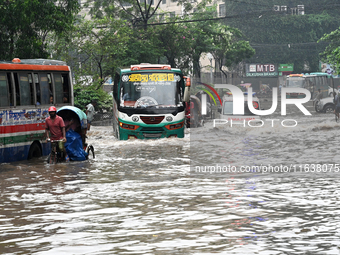 Vehicles and rickshaws drive with passengers through the waterlogged streets of Dhaka, Bangladesh, on October 5, 2024, after heavy rainfalls...