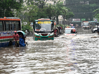 Vehicles and rickshaws drive with passengers through the waterlogged streets of Dhaka, Bangladesh, on October 5, 2024, after heavy rainfalls...