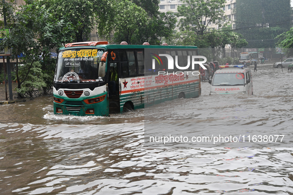 Vehicles and rickshaws drive with passengers through the waterlogged streets of Dhaka, Bangladesh, on October 5, 2024, after heavy rainfalls...