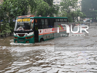 Vehicles and rickshaws drive with passengers through the waterlogged streets of Dhaka, Bangladesh, on October 5, 2024, after heavy rainfalls...