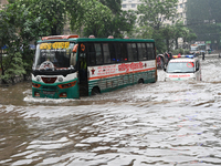 Vehicles and rickshaws drive with passengers through the waterlogged streets of Dhaka, Bangladesh, on October 5, 2024, after heavy rainfalls...