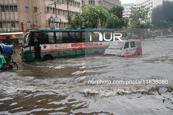 Vehicles and rickshaws drive with passengers through the waterlogged streets of Dhaka, Bangladesh, on October 5, 2024, after heavy rainfalls...