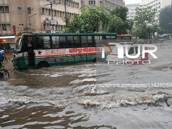 Vehicles and rickshaws drive with passengers through the waterlogged streets of Dhaka, Bangladesh, on October 5, 2024, after heavy rainfalls...