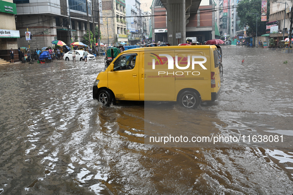 Vehicles and rickshaws drive with passengers through the waterlogged streets of Dhaka, Bangladesh, on October 5, 2024, after heavy rainfalls...