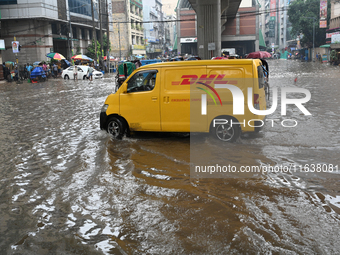 Vehicles and rickshaws drive with passengers through the waterlogged streets of Dhaka, Bangladesh, on October 5, 2024, after heavy rainfalls...