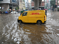 Vehicles and rickshaws drive with passengers through the waterlogged streets of Dhaka, Bangladesh, on October 5, 2024, after heavy rainfalls...