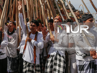 Balinese men make pyramid-like structures using long wooden sticks during the Mekotek ritual in Munggu Village, Bali, Indonesia, on October...